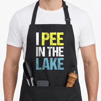 Pee summer aprons - Stacked text reading I PEE IN THE LAKE in yellow white and light blue — shown on a black cotton canvas apron against a white background