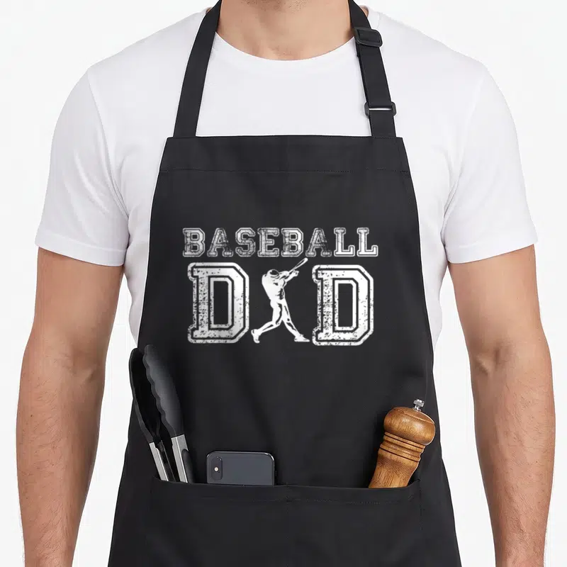 Baseball grill daddy apron - White distressed baseball dad text with batter silhouette between the Ds — shown on a black cotton canvas apron against a white background