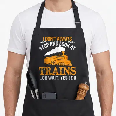 Alway train conductor apron - Orange steam locomotive with white smoke and stacked text reading I Don't Always Stop — shown on a black cotton canvas apron against a white background