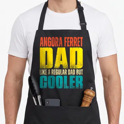 Angora ferret dad apron - Stacked red yellow teal beige distressed text reading Angora Ferret Dad Like a Regular Dad — shown on a black cotton canvas apron against a white background