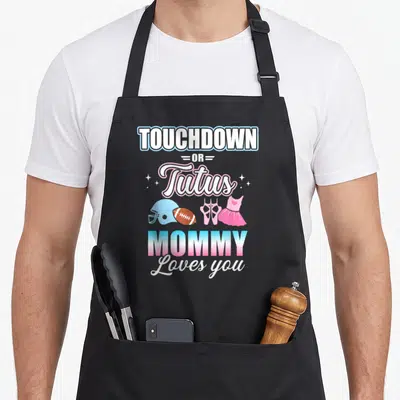 Touchdown apron or apron - Stacked text reading TOUCHDOWN OR Tutus MOMMY Loves you above football helmet, ball, ballet — shown on a black cotton canvas apron against a white background