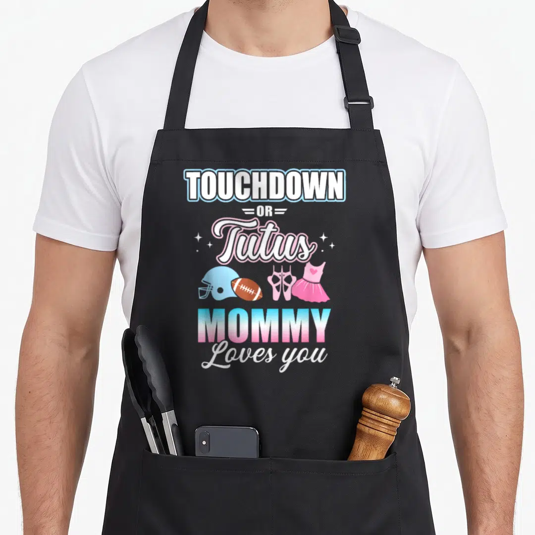 Touchdown apron or apron - Stacked text reading TOUCHDOWN OR Tutus MOMMY Loves you above football helmet, ball, ballet — shown on a black cotton canvas apron against a white background