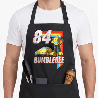 Bumblebee stripe apron - 84 Bumblebee robot yellow car cartoon print with rainbow stripe — shown on a black cotton canvas apron against a white background