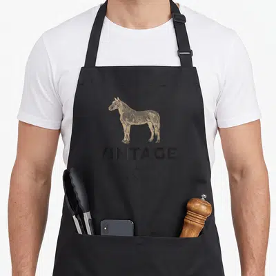 Wild horse apron - Tan horse drawing above VINTAGE WILD HORSES EST X 1898 text — shown on a black cotton canvas apron against a white background