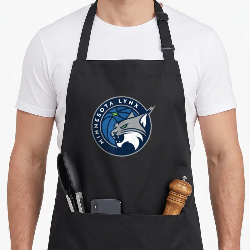 Base basketball fan apron - MINNESOTA LYNX text arching over cartoon lynx head and blue basketball inside navy circle — shown on a black cotton canvas apron against a white background