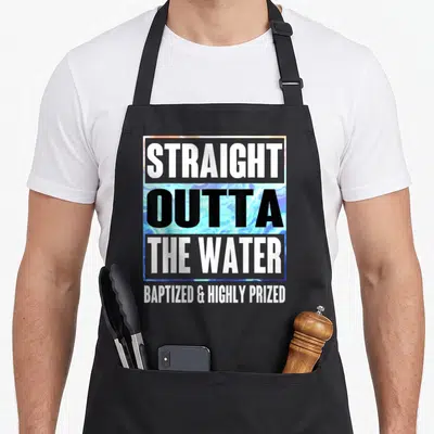 Baptism water apron - Stacked text reading straight outta the water baptized and highly prized over blue swirl — shown on a black cotton canvas apron against a white background