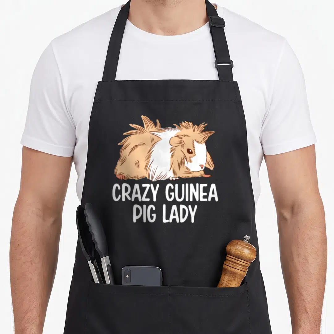 Animal crazy cavy lady apron - Brown and white cartoon guinea pig above white text reading CRAZY GUINEA PIG LADY — shown on a black cotton canvas apron against a white background