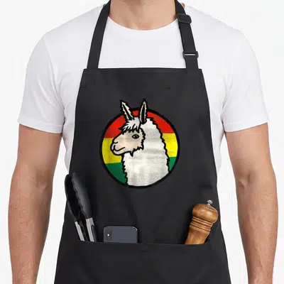 Bolivia travel aprons - Cartoon llama head centered on red yellow green white circular stripes — shown on a black cotton canvas apron against a white background