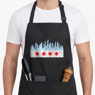 Flag distressed chicago apron - Light blue skyline silhouette above four red stars on a white distressed band — shown on a black cotton canvas apron against a white background