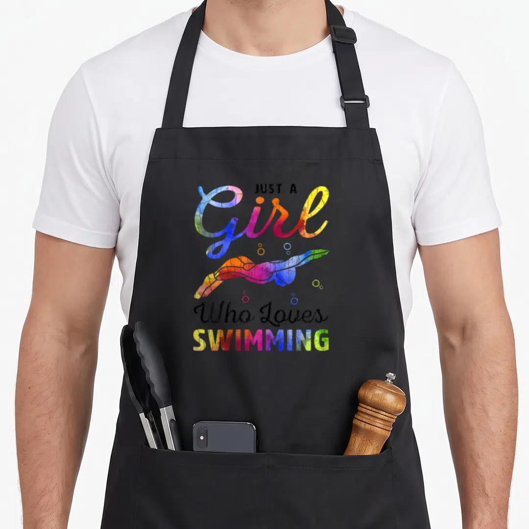 Swimming swimmer apron - Just A Girl Who Loves Swimming text with watercolor swimmer and bubbles in blue pink yellow — shown on a black cotton canvas apron against a white background