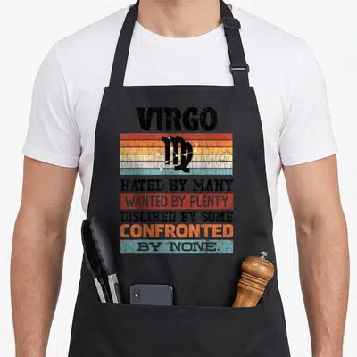 Hated zodiac aprons - Virgo text on black orange red blue yellow retro stripes with constellation symbol — shown on a black cotton canvas apron against a white background