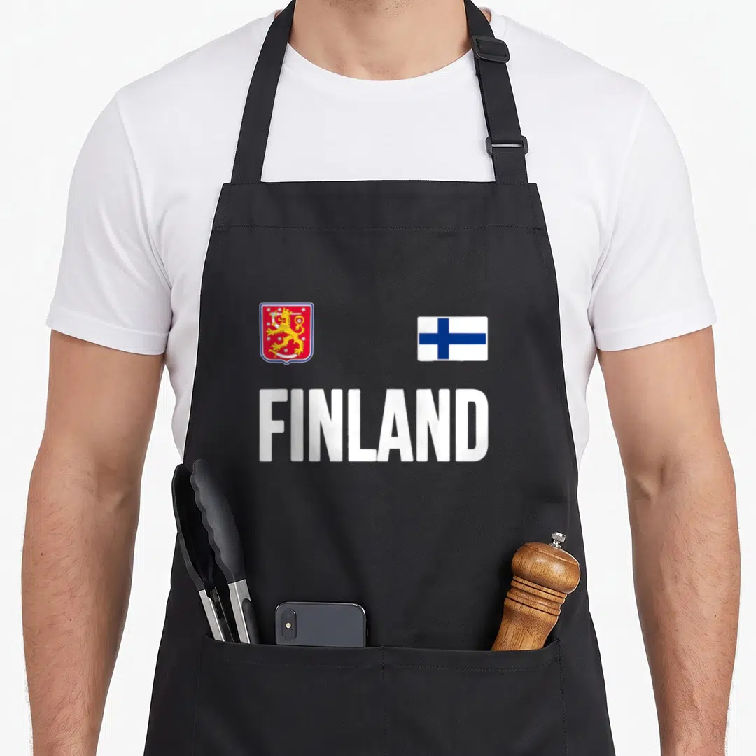 Suomi finnish apron - Coat of arms and flag above white FINLAND text in red blue gold — shown on a black cotton canvas apron against a white background