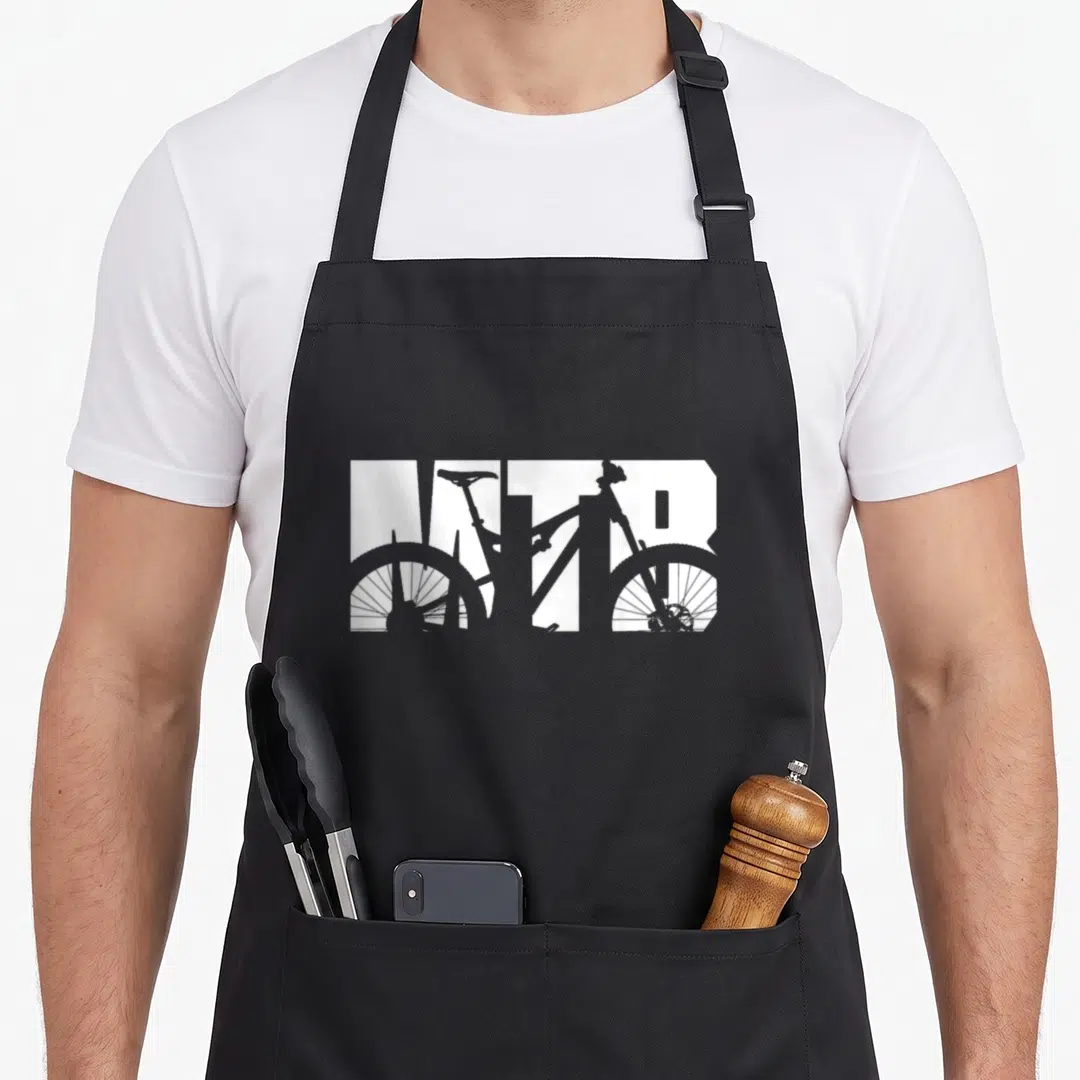 Mountain biker bike apron - Grey mountain bike silhouette overlaid on white MTB block letters — shown on a black cotton canvas apron against a white background