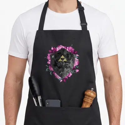 Shield floral apron - Grey shield with gold triforce surrounded by pink purple roses and green leaves — shown on a black cotton canvas apron against a white background