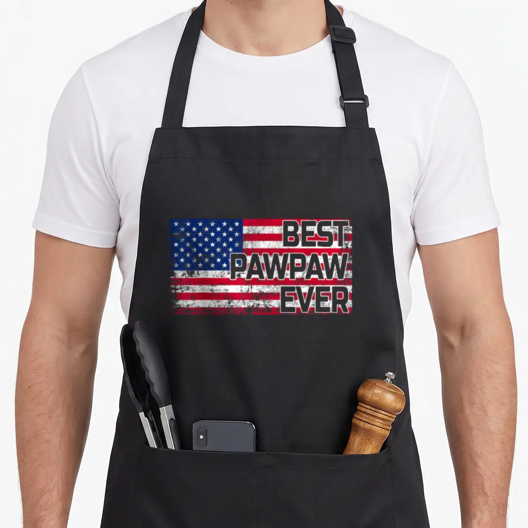 Pawpaw american flag apron - Distressed USA flag with stacked BEST PAWPAW EVER text in gray — shown on a black cotton canvas apron against a white background