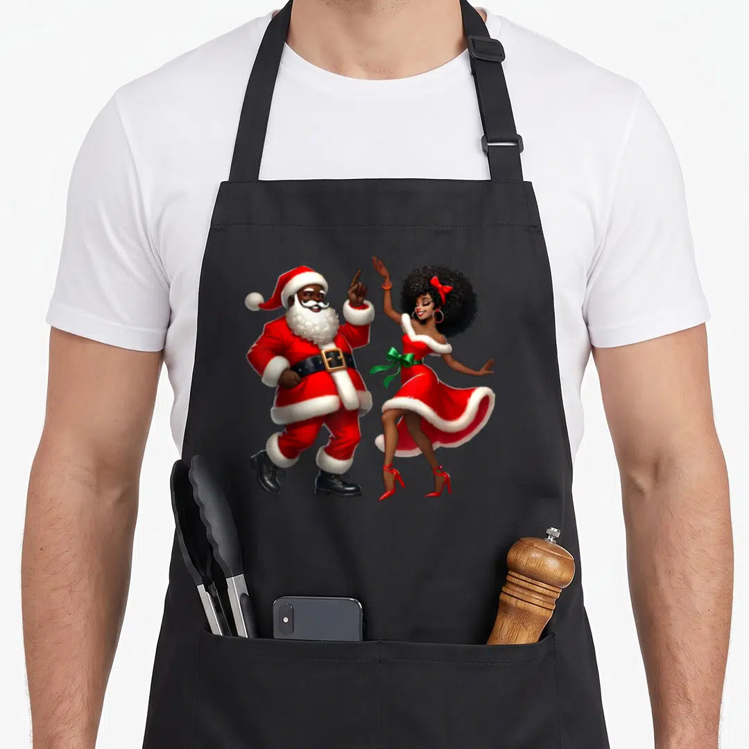 African mrs apron - Cartoon Santa pointing up beside dancing woman in red dress with green bow — shown on a black cotton canvas apron against a white background