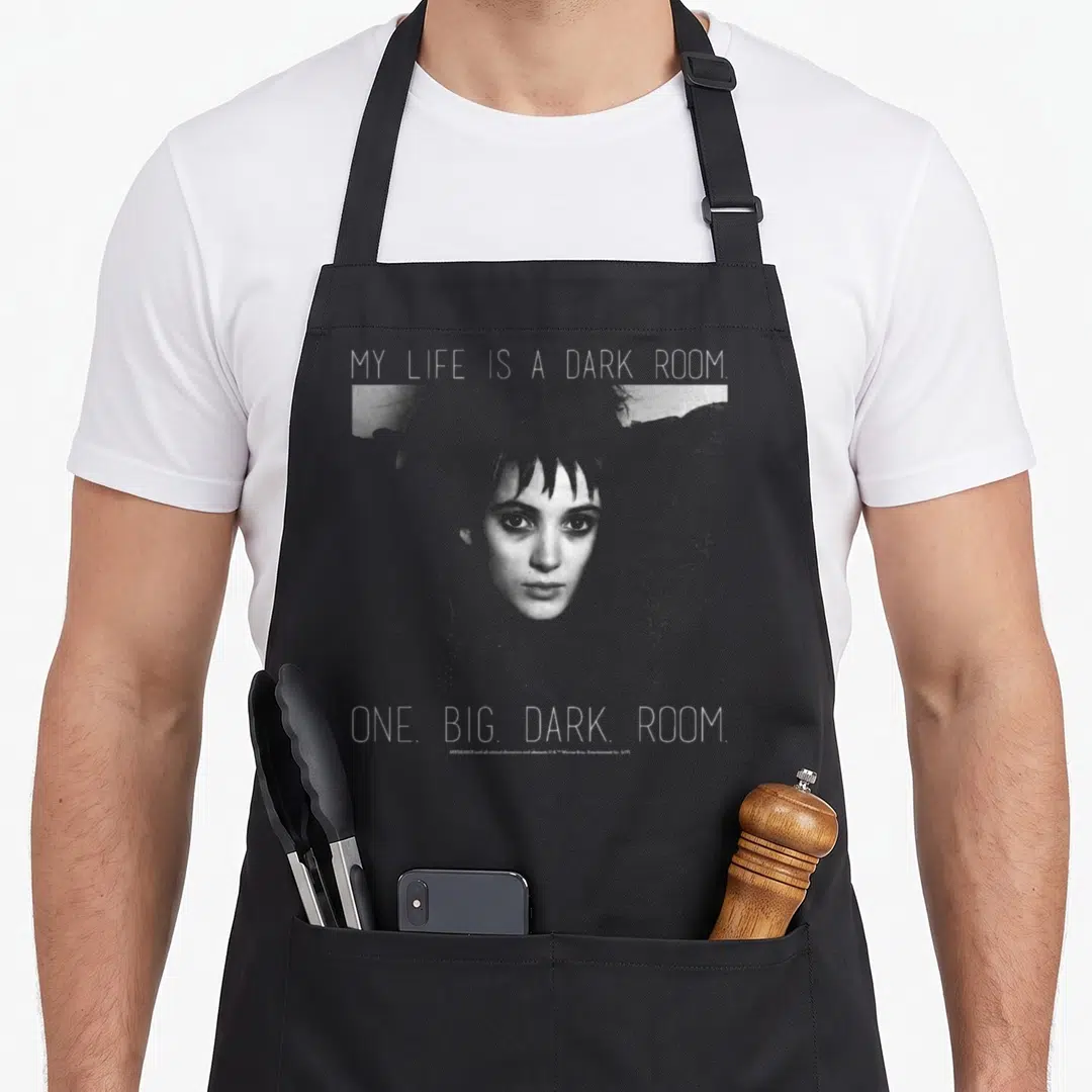 Lydia beetle apron - Woman's face with text My Life Is A Dark Room in grey and white on black background — shown on a black cotton canvas apron against a white background