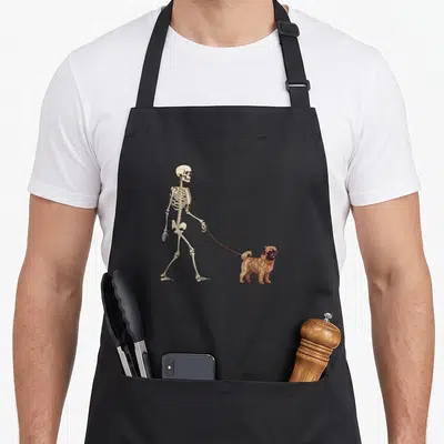 Halloween dog apron - Beige skeleton walking brown Brussels Griffon on red leash cartoon illustration — shown on a black cotton canvas apron against a white background