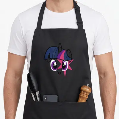 Twilight face apron - Cartoon pony head with purple mane, pink star overlap, and smiling face — shown on a black cotton canvas apron against a white background