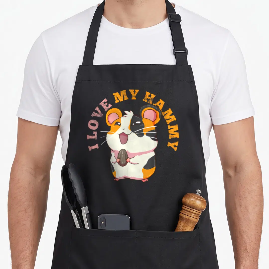 Funny best hamster apron - Cartoon hamster holding a seed with I LOVE MY HAMMY text arched above — shown on a black cotton canvas apron against a white background