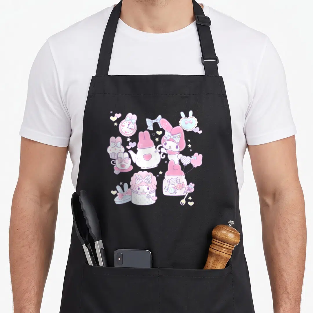 Melody tea party aprons - Pink cartoon rabbit with teapot, cupcake, candy jar, and hearts in blue and yellow — shown on a black cotton canvas apron against a white background
