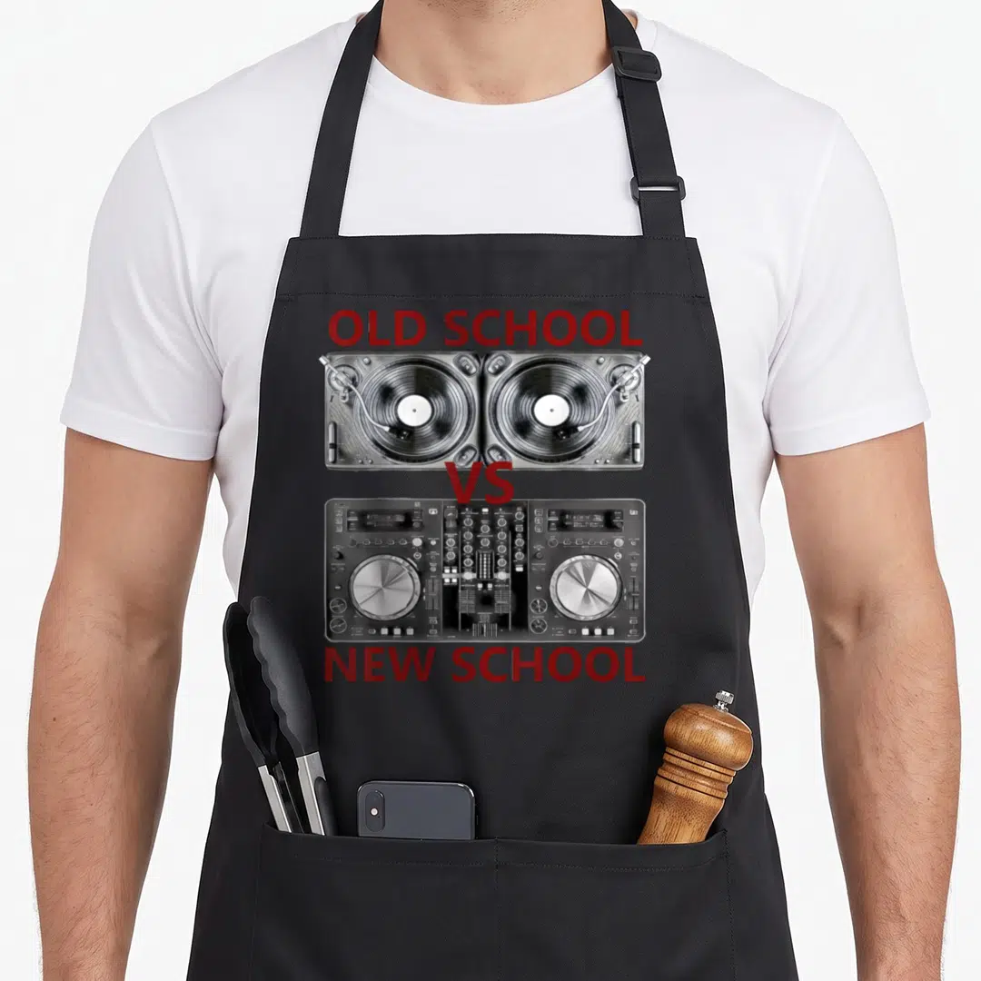 Dance djing apron - OLD SCHOOL VS NEW SCHOOL text with turntables and controller in red grey black white — shown on a black cotton canvas apron against a white background