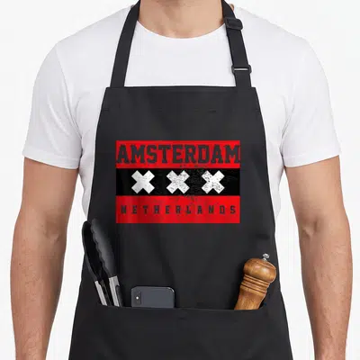 Cute amsterdam apron - Red black rectangle with grey AMSTERDAM text, three white crosses, and NETHERLANDS at bottom — shown on a black cotton canvas apron against a white background