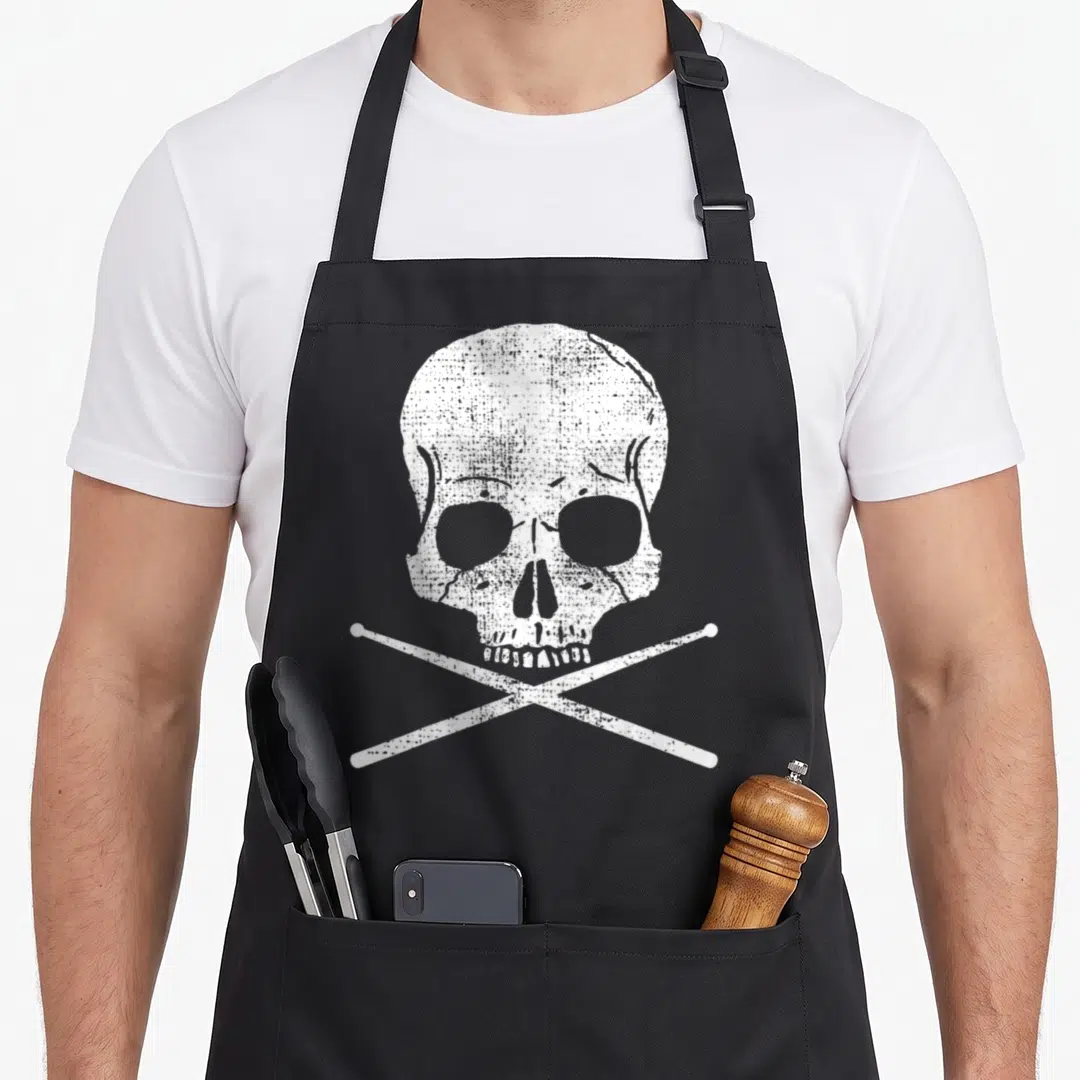 Death drumsticks apron - White distressed skull above two crossed drumsticks on black fabric — shown on a black cotton canvas apron against a white background