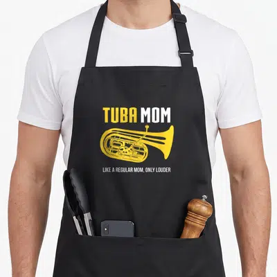 Band tuba apron - Yellow tuba illustration with TUBA MOM text in distressed yellow and white fonts — shown on a black cotton canvas apron against a white background