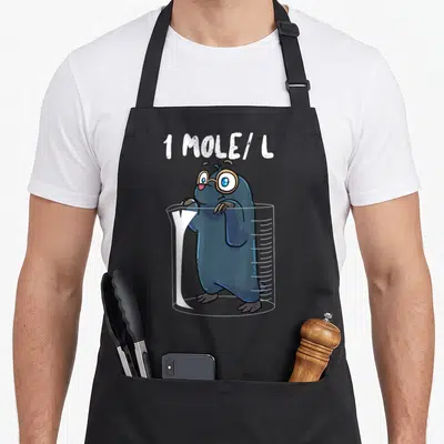 Chemist chemistry apron - Cartoon mole in beaker with 1 MOLE/L text and glasses — shown on a black cotton canvas apron against a white background