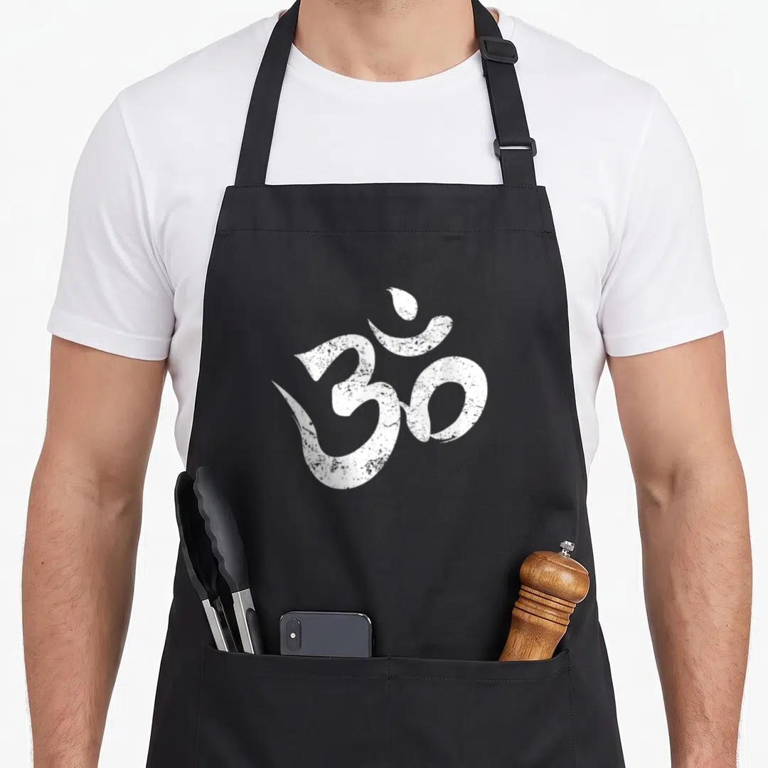 Meditation distressed apron - White distressed Om symbol printed on a black bib apron background — shown on a black cotton canvas apron against a white background