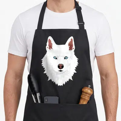 Canine husky apron - Minimalist white dog head with blue eyes and brown inner ears — shown on a black cotton canvas apron against a white background