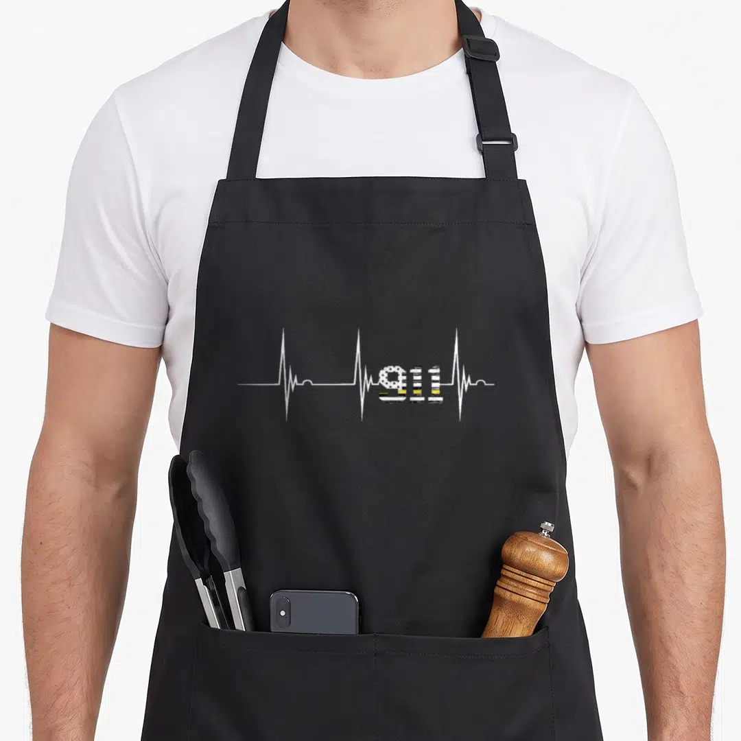 Flag dispatcher apron - White EKG line with 911 in black white and yellow striped flag pattern — shown on a black cotton canvas apron against a white background