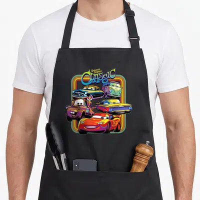 Radiator cars apron - Five cartoon cars in multicolored frame with text reading Radiator Springs Classic — shown on a black cotton canvas apron against a white background