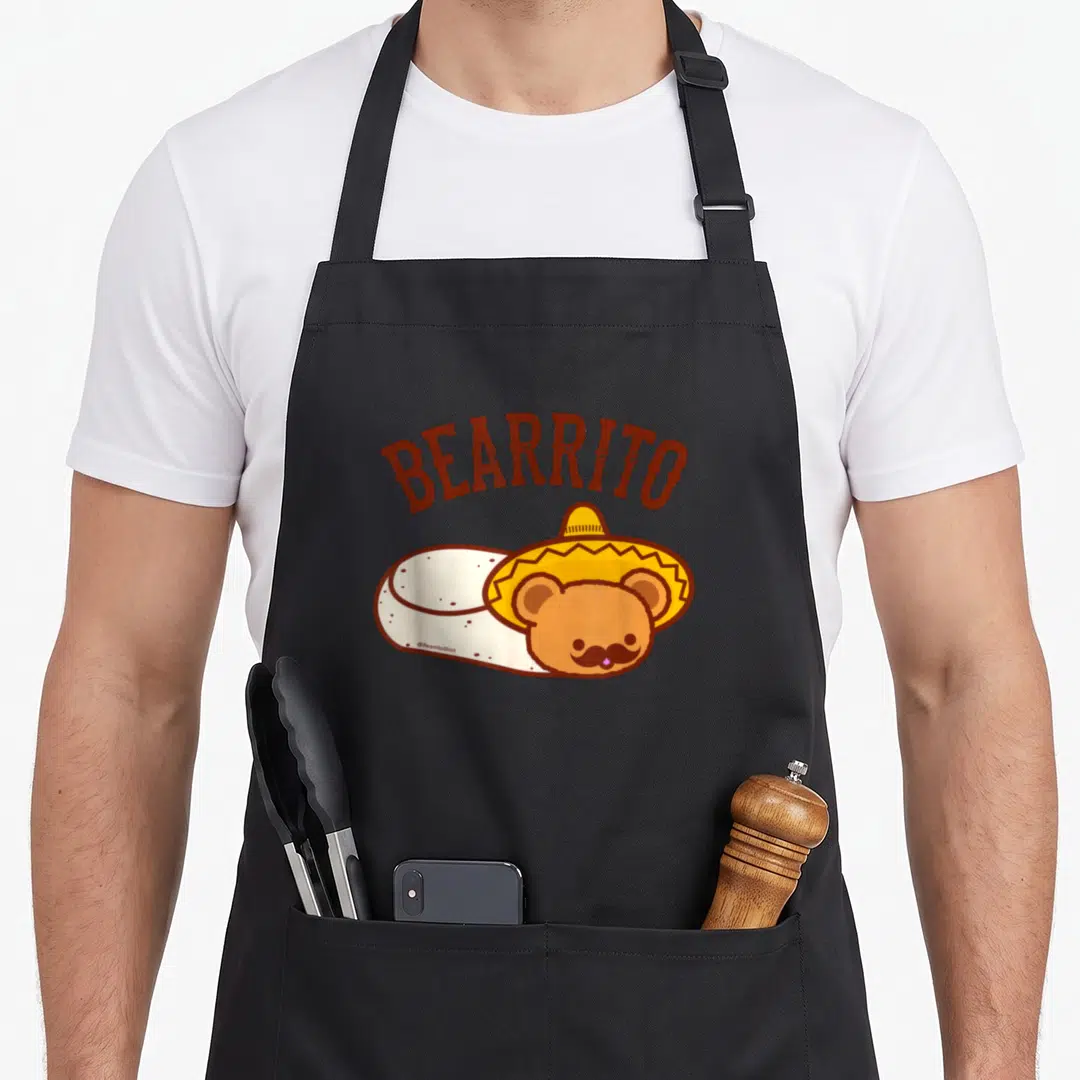 Mexican teddy bear apron - Arched BEARRITO text above a brown bear in a sombrero wrapped in a cream tortilla — shown on a black cotton canvas apron against a white background