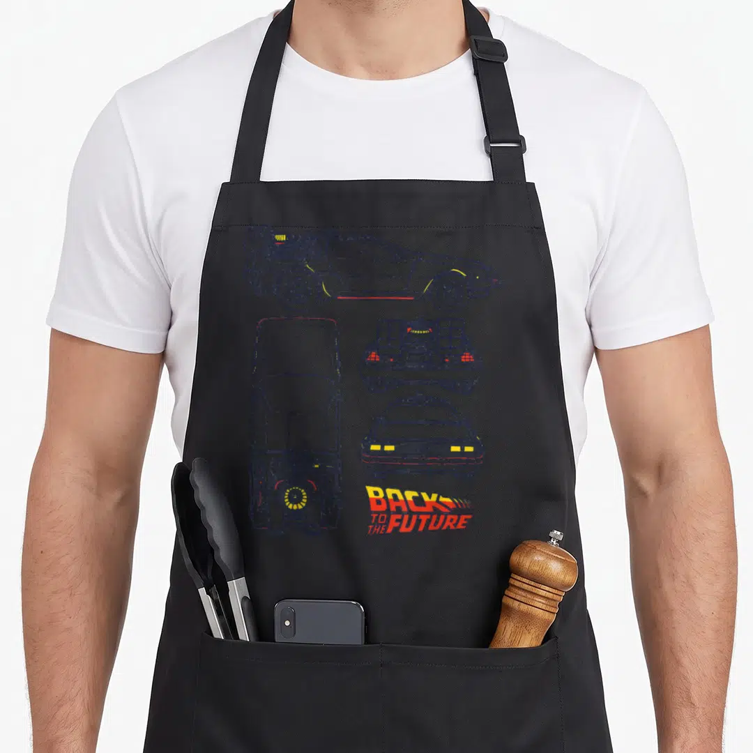 Delorean future class apron - Three schematic DeLorean views with Back to the Future title in blue yellow and red line — shown on a black cotton canvas apron against a white background