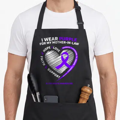 Dementia mother's apron - Purple ribbon inside white sketched heart with I WEAR PURPLE FOR MY MOTHER-IN-LAW text — shown on a black cotton canvas apron against a white background