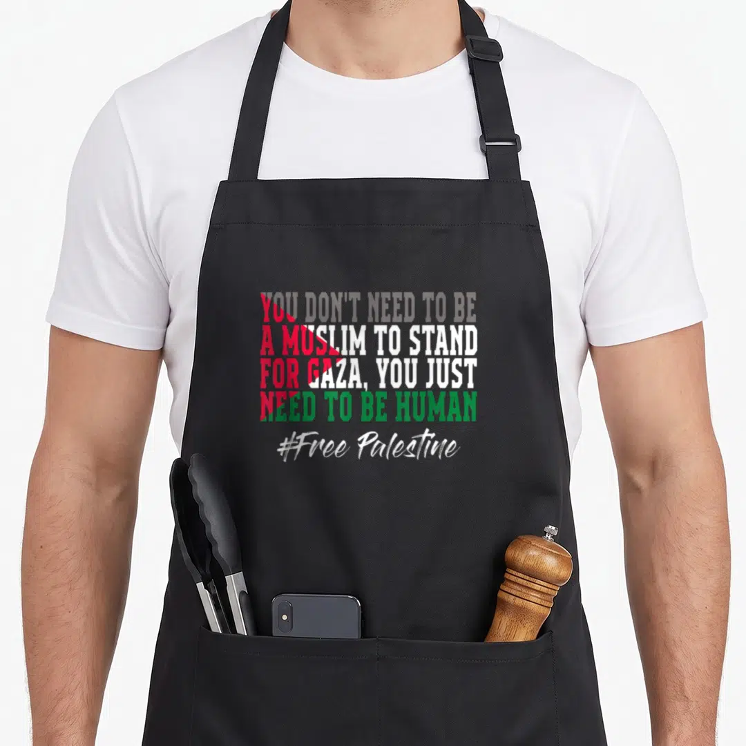 Free palestinian apron - Stacked red white green black text reading you dont need to be a muslim to stand for gaza you — shown on a black cotton canvas apron against a white background