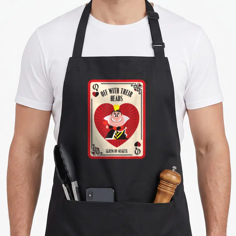 Their queen apron - Cartoon Queen of Hearts inside red heart on playing card with Off With Their Heads text — shown on a black cotton canvas apron against a white background