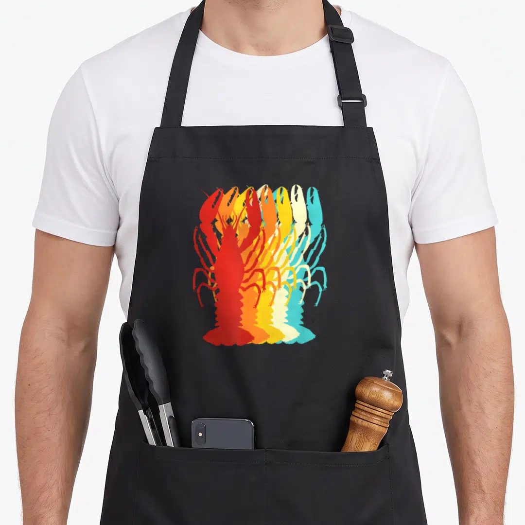 Miftee mardi gras aprons - Retro lobster silhouette printed in red, orange, yellow, cream, and cyan layers — shown on a black cotton canvas apron against a white background