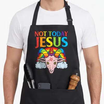 Today goat apron - Not Today Jesus rainbow text over pink goat head with flame and pentagram — shown on a black cotton canvas apron against a white background