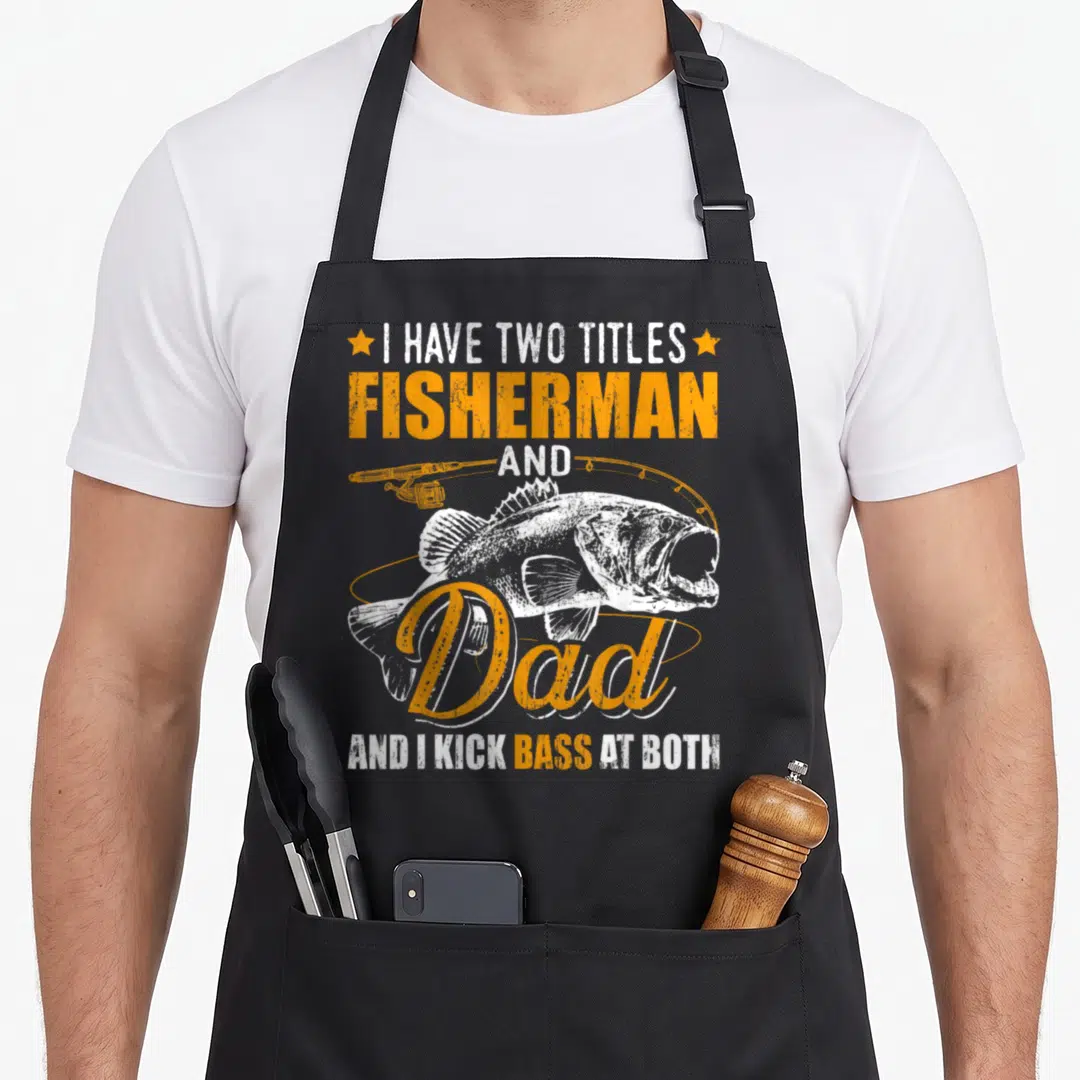Fisherman father day apron - I Have Two Titles Fisherman Dad bass fish fishing rod distressed print — shown on a black cotton canvas apron against a white background