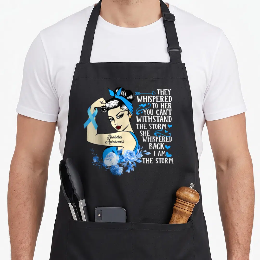 Month diabetes awareness apron - Cartoon woman flexing blue ribbon and storm quote text with blue roses — shown on a black cotton canvas apron against a white background