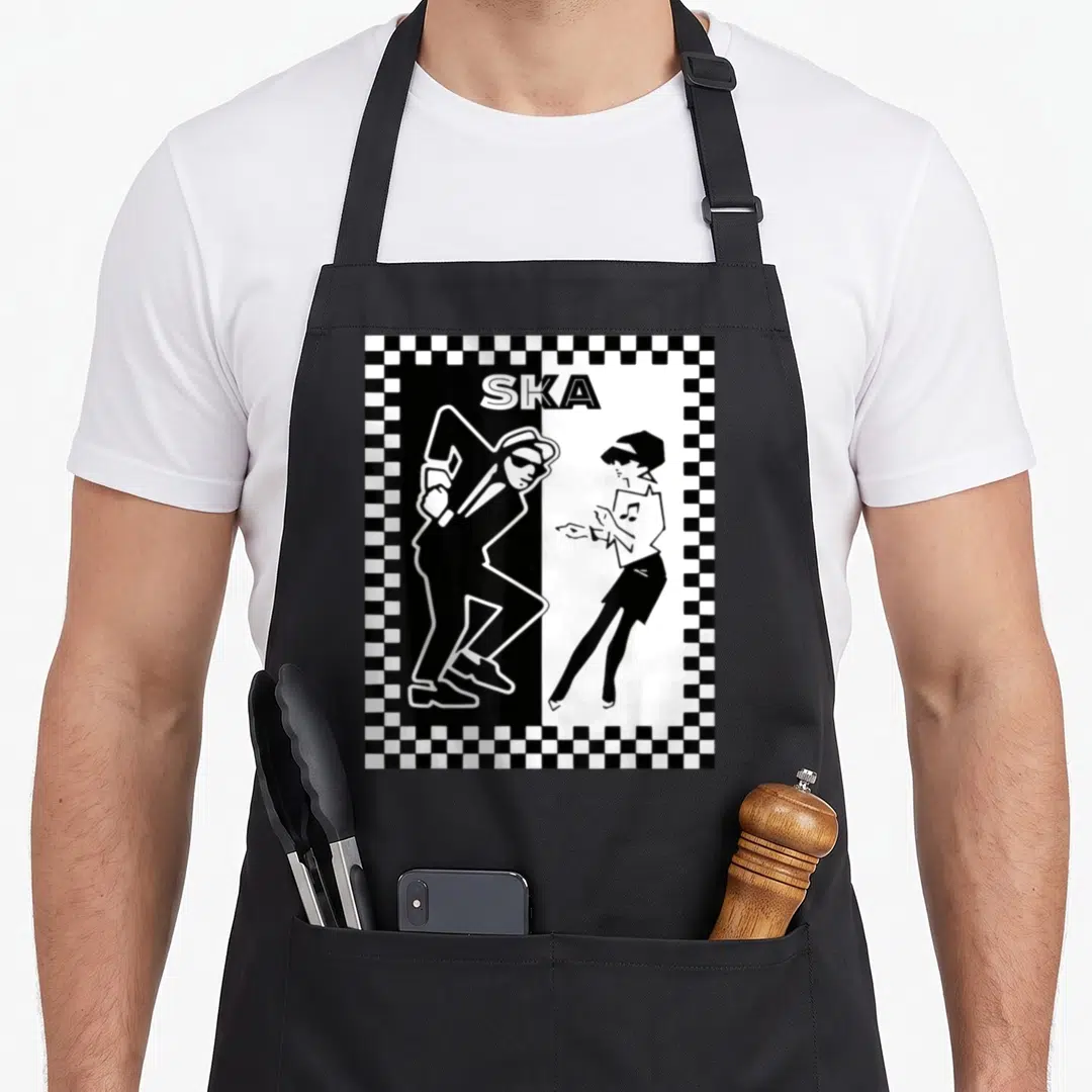 Reggae ska apron - Two dancers in black and white under SKA text inside a checkerboard border — shown on a black cotton canvas apron against a white background