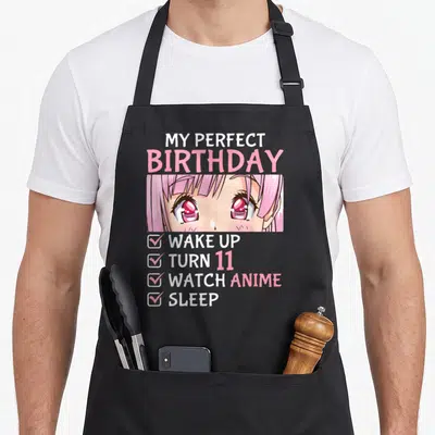 Watch anime mom apron - My Perfect Birthday text above anime girl eyes and four-item checklist in pink white red — shown on a black cotton canvas apron against a white background