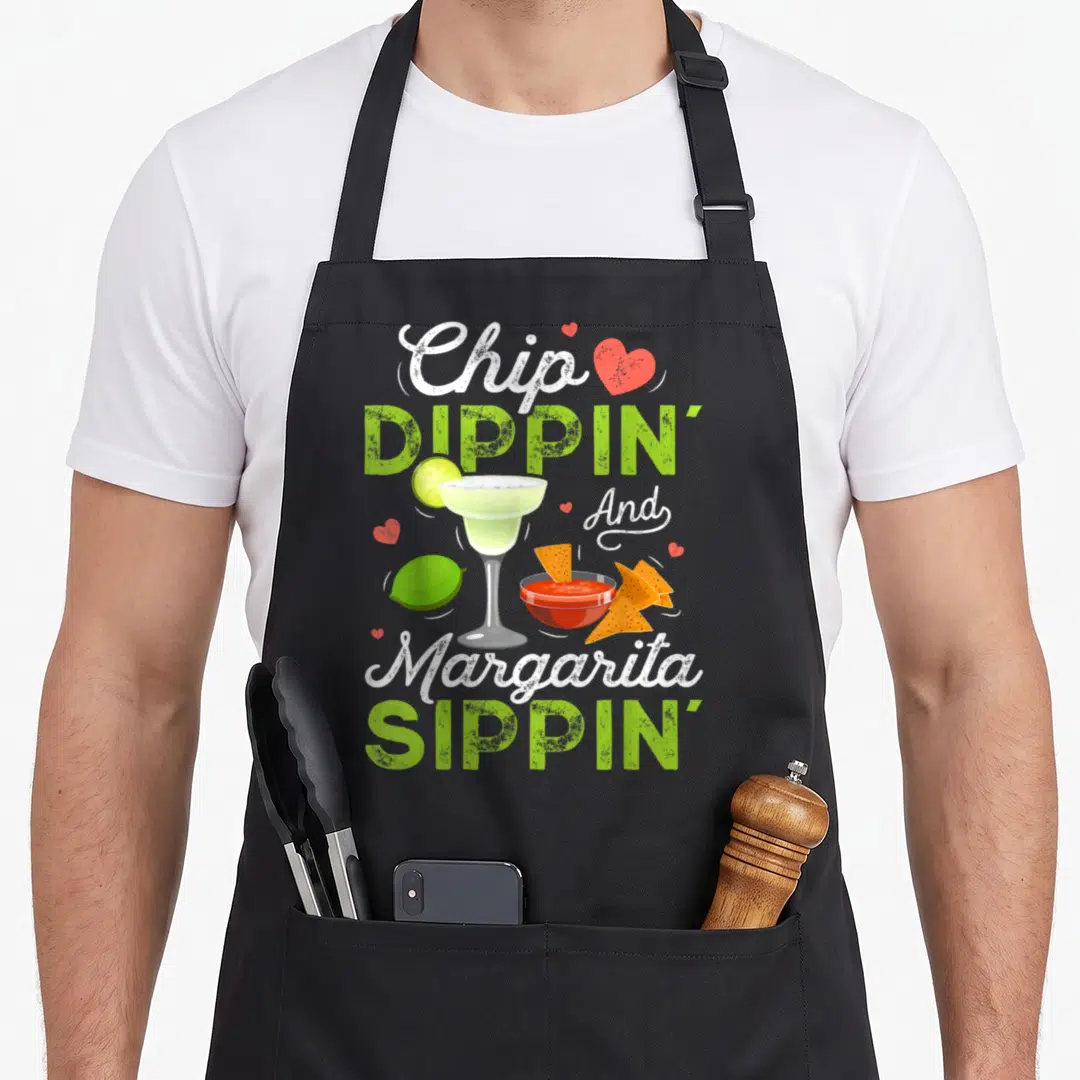 Dippin chips apron - Stacked Chip Dippin Margarita Sippin text with margarita glass, red salsa bowl, and hearts — shown on a black cotton canvas apron against a white background