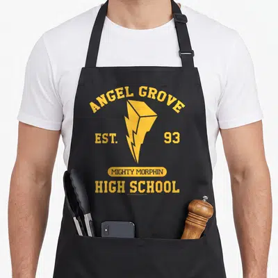 Grove angels and aprons - Yellow lightning bolt with Angel Grove High School established 93 typography on black fabric — shown on a black cotton canvas apron against a white background