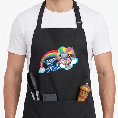 Dream hair apron - Grey troll with rainbow hair and BIG HAIR BIG DREAMS text next to rainbow arch — shown on a black cotton canvas apron against a white background