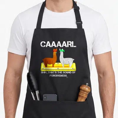 Lamas llama dad apron - Two llamas in yellow tray with CAAAARL and forgiveness text — shown on a black cotton canvas apron against a white background