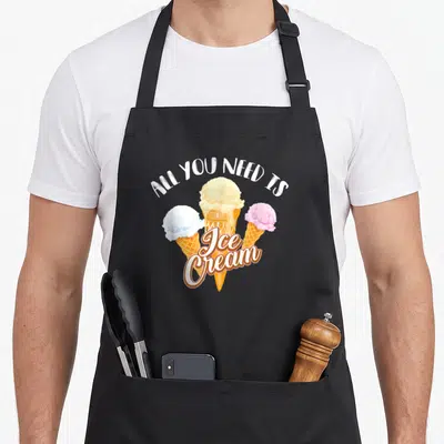 Dessert ice cream apron - Three ice cream cones in white yellow blue pink and orange under arched text — shown on a black cotton canvas apron against a white background